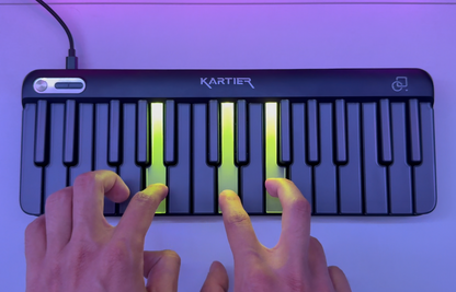 Kartier keyboard being played with hands on a purple background